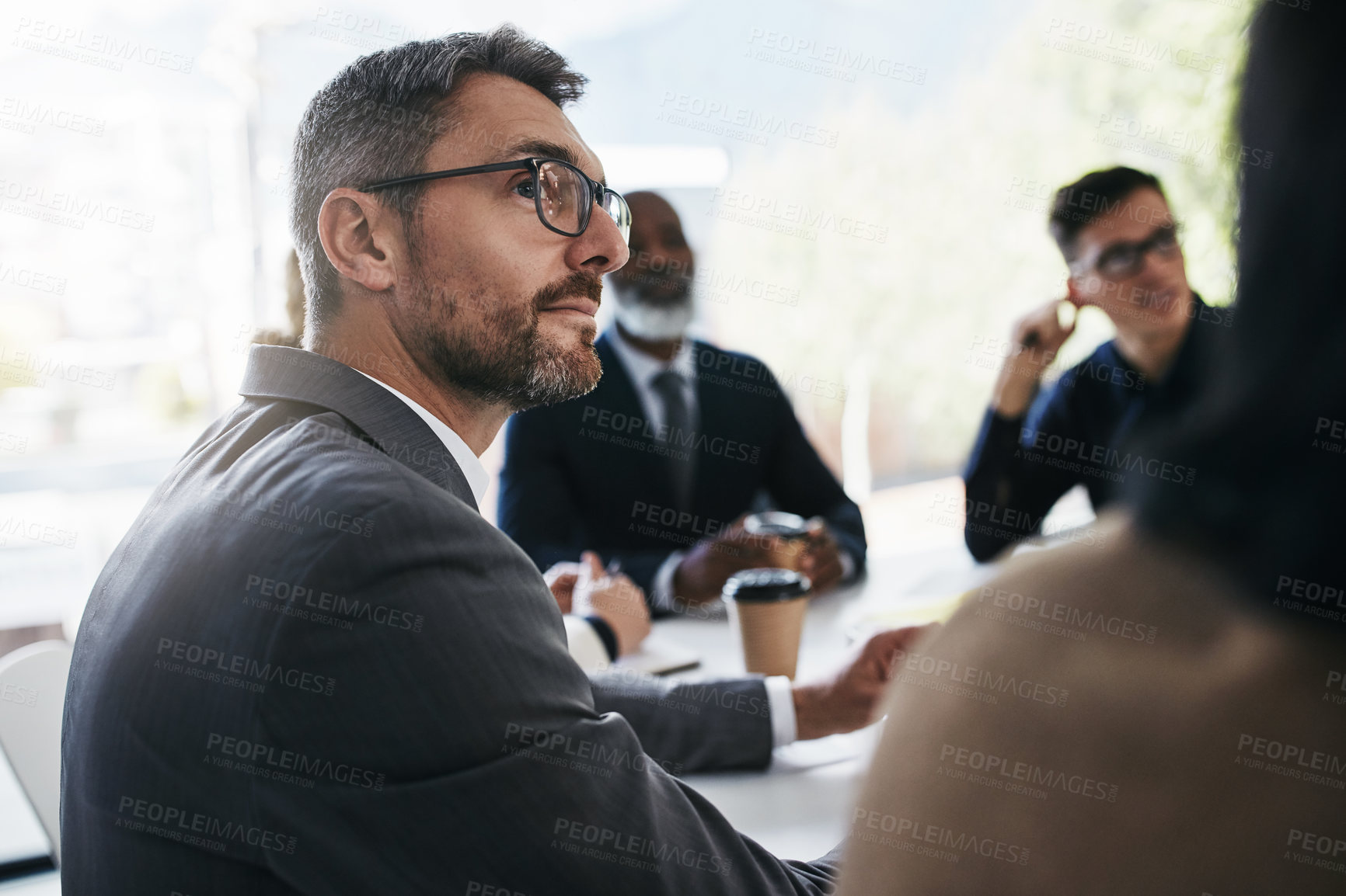 Buy stock photo Shot of a businessman having a meeting with his colleagues in an office
