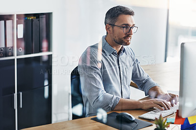 Buy stock photo Cropped shot of a businessman working on his computer at his desk