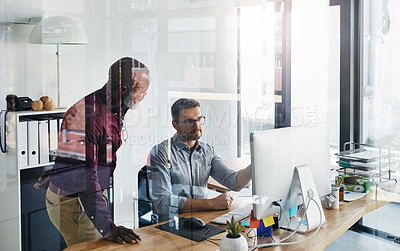 Buy stock photo Shot of two businesspeople working on a computer in an office