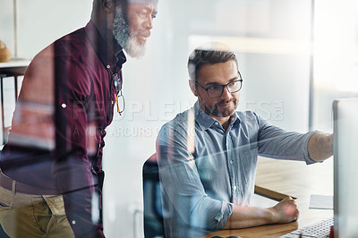 Buy stock photo Shot of two businesspeople working on a computer in an office