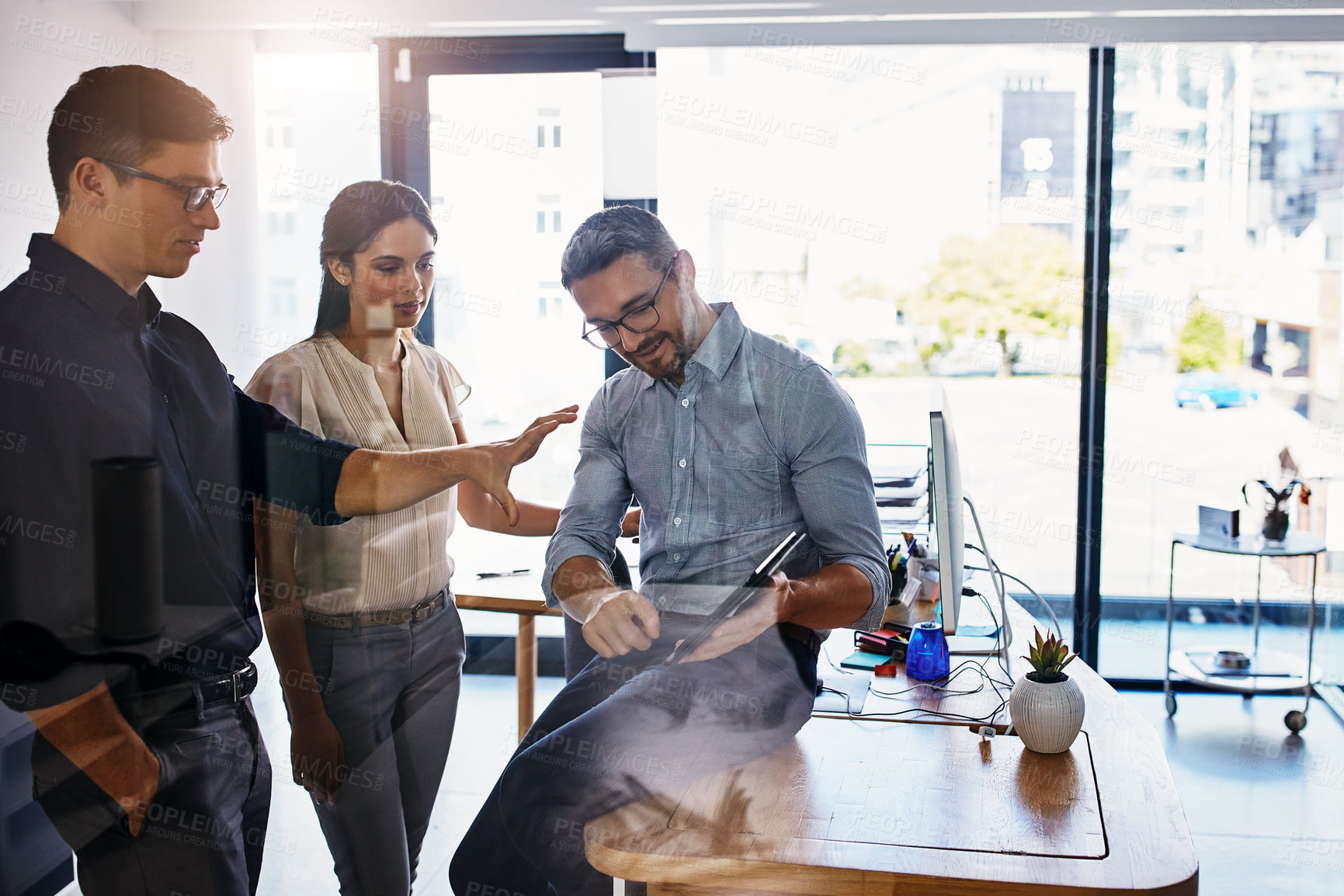 Buy stock photo Shot of a group of businesspeople using a digital tablet in an office