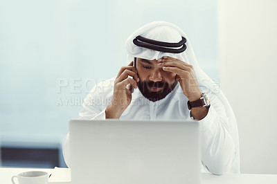 Buy stock photo Cropped shot of a young businessman dressed in Islamic traditional clothing looking stressed while working in his office