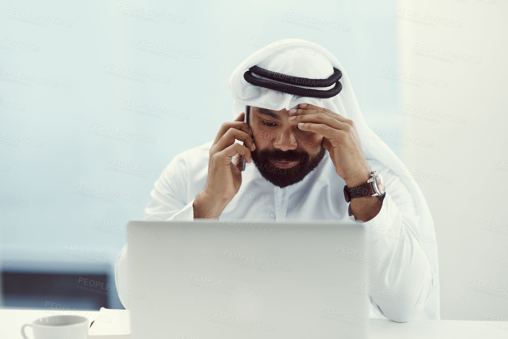 Buy stock photo Cropped shot of a young businessman dressed in Islamic traditional clothing looking stressed while working in his office