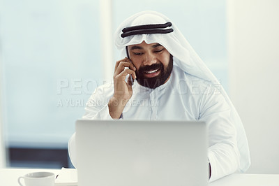 Buy stock photo Cropped shot of a young businessman dressed in Islamic traditional clothing using his cellphone while working in his office