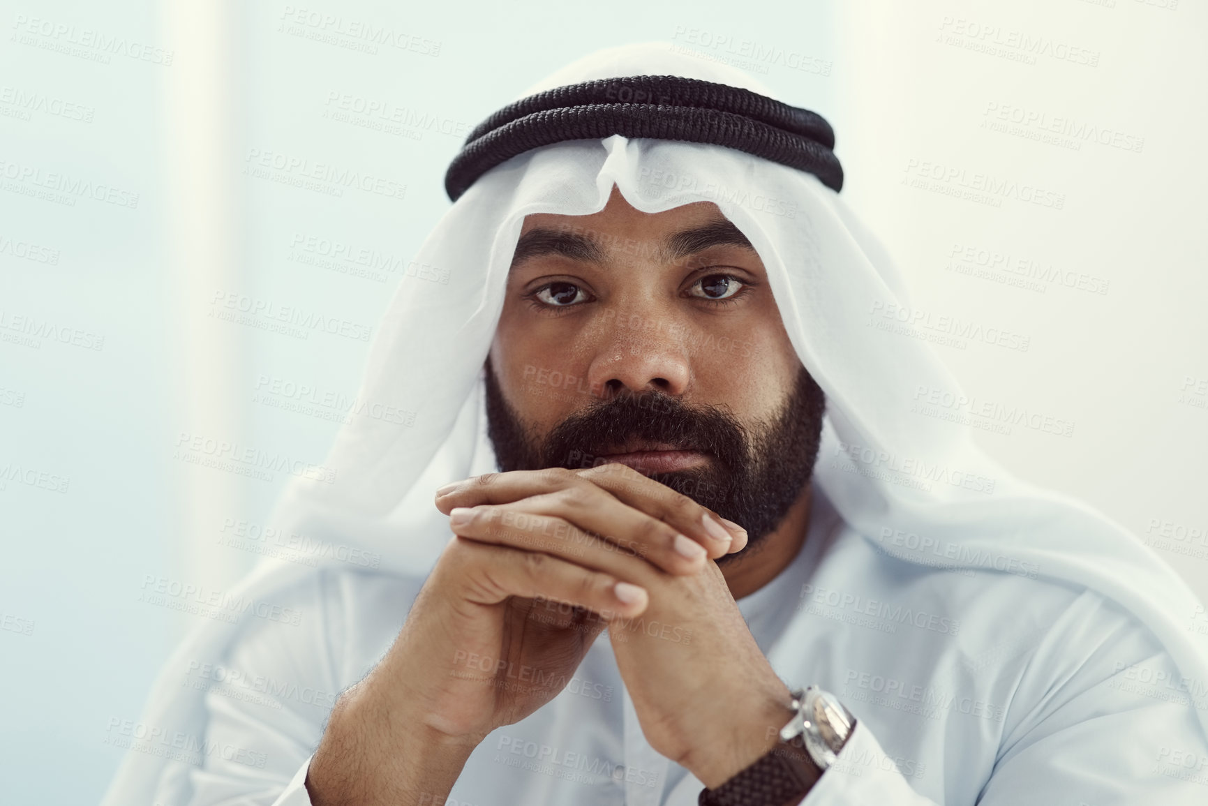 Buy stock photo Cropped portrait of a young businessman dressed in Islamic traditional clothing working in his office