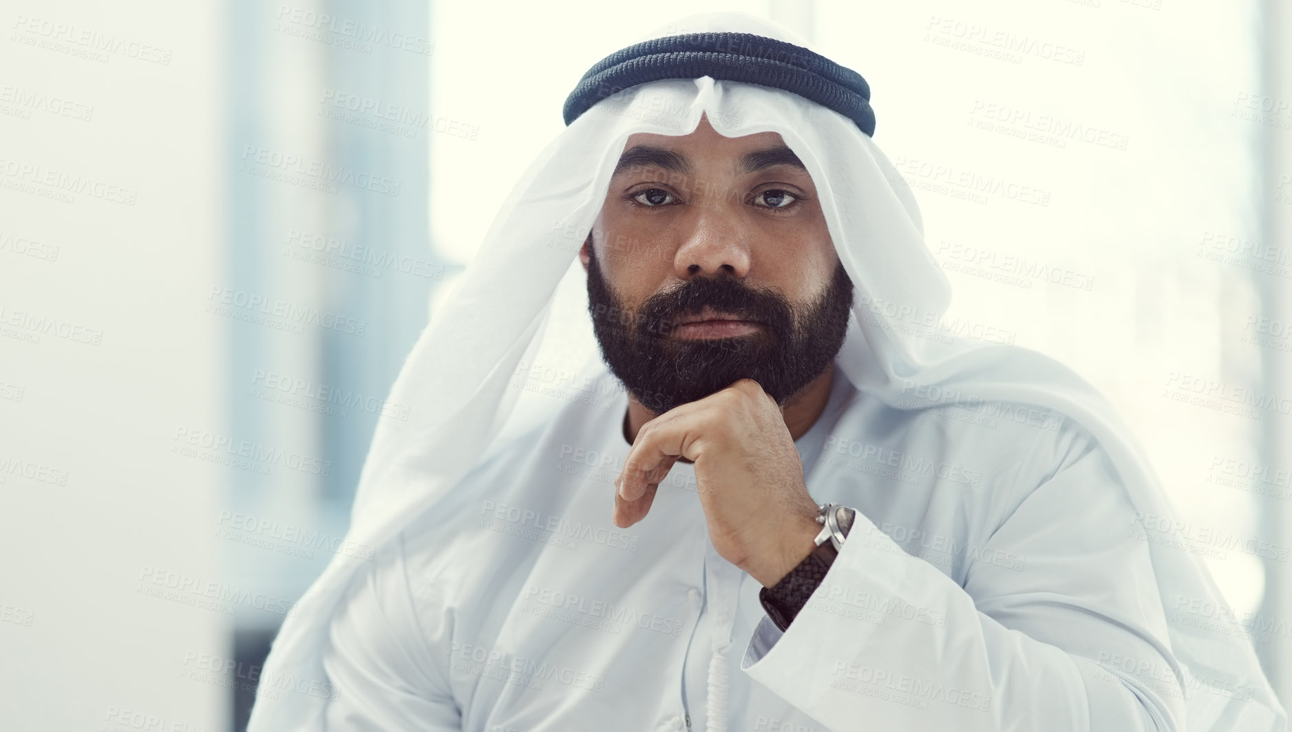 Buy stock photo Cropped portrait of a young businessman dressed in Islamic traditional clothing working in his office