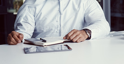 Buy stock photo Cropped shot of an unrecognizable businessman dressed in Islamic traditional clothing working in his office