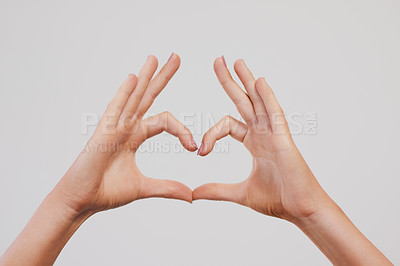 Buy stock photo Studio shot of a unrecognizable person's hands making a heart shape against a grey background
