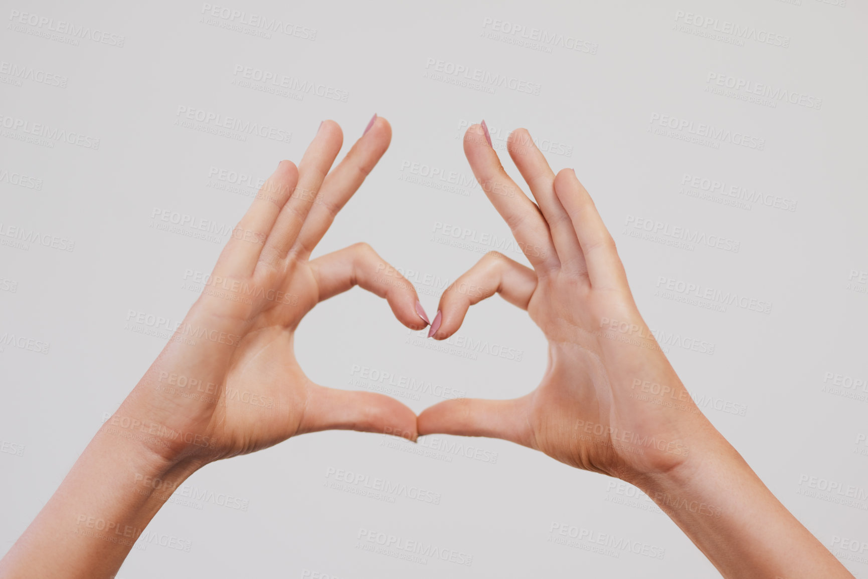 Buy stock photo Studio shot of a unrecognizable person's hands making a heart shape against a grey background
