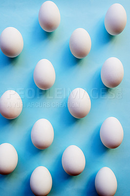 Buy stock photo Studio shot of a bunch of eggs against a colored background neatly placed in rows