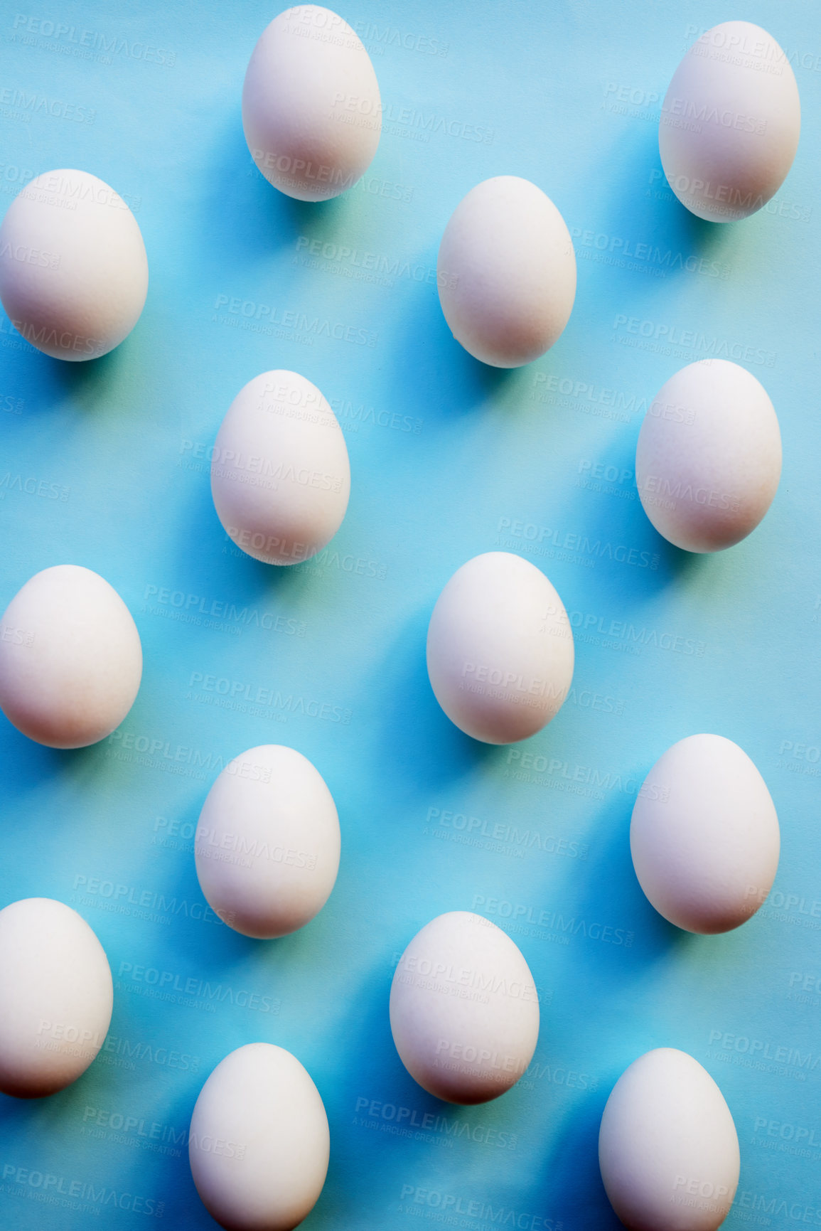 Buy stock photo Studio shot of a bunch of eggs against a colored background neatly placed in rows