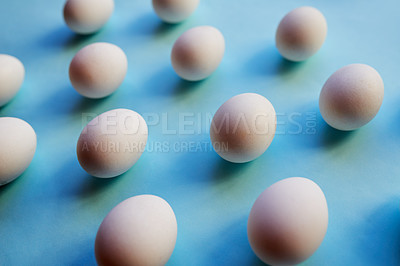 Buy stock photo Studio shot of a bunch of eggs against a colored background neatly placed in rows