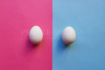 Buy stock photo Studio shot of two eggs placed on two different colored backgrounds next to each other
