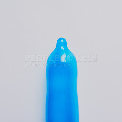 Buy stock photo Blue, condom or latex in studio for education, sexual health or STD awareness. Contraception, safety or responsibility on gray background for creativity, HIV prevention or rubber for protection