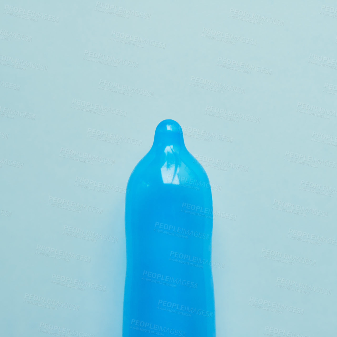 Buy stock photo Studio shot of a blue condom placed against a blue background