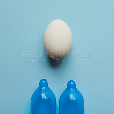 Buy stock photo Eggs,  condom and studio background as prevention for birth rate, reproduction and contraceptive. Embryo, safety and protection for pregnancy to manage fertility for new life and control population