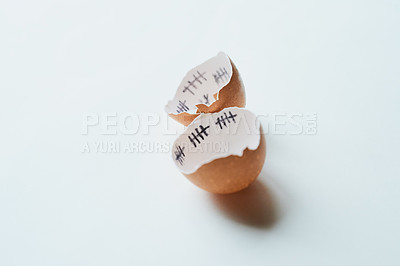 Buy stock photo Studio shot of two pieces of broken egg shell against a white background with tally marks inside of it