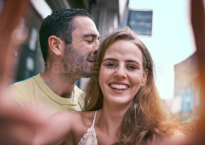 Buy stock photo Shot of a happy young couple taking selfies while exploring a foreign city