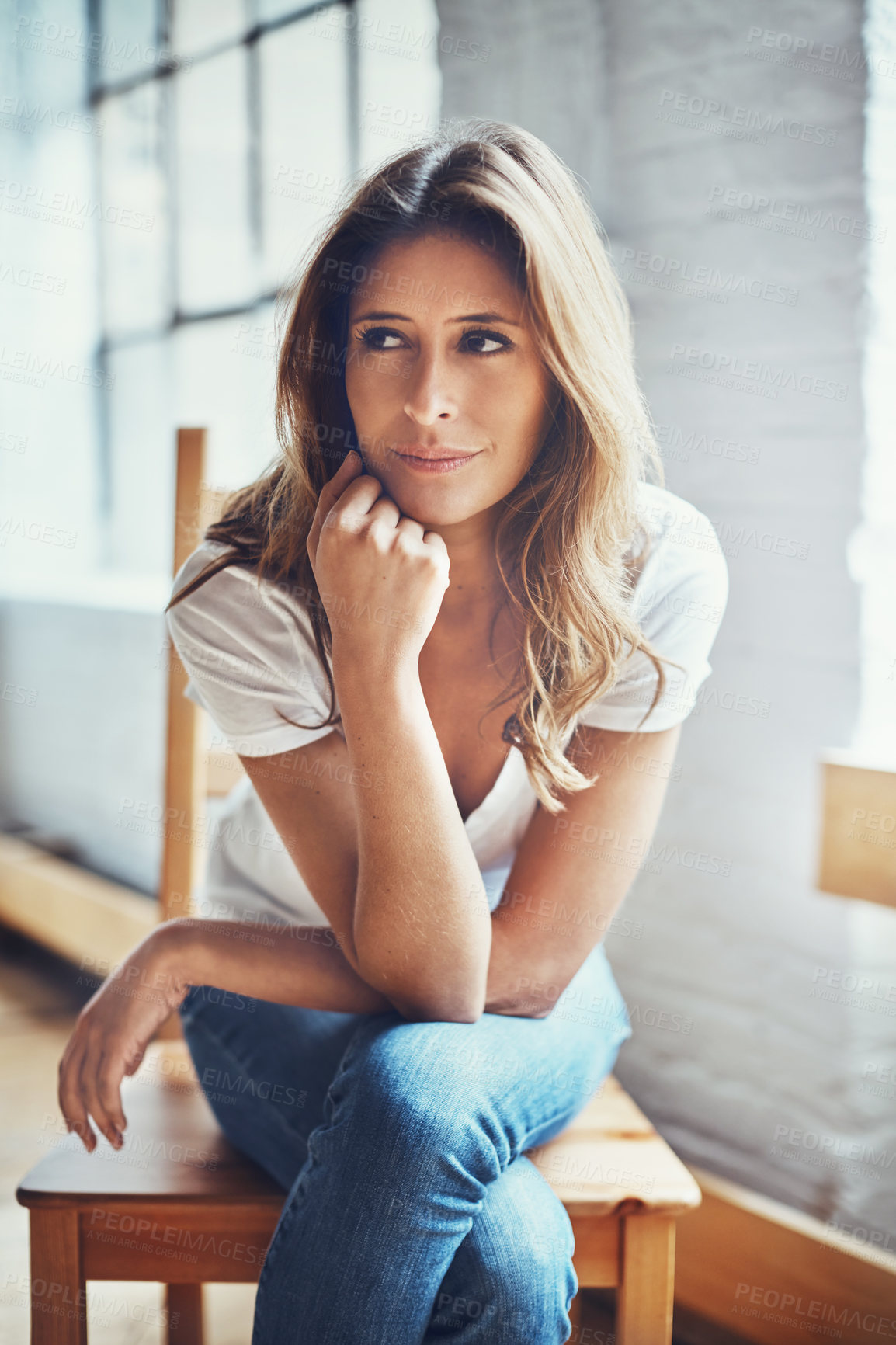 Buy stock photo Shot of an attractive and thoughtful young woman relaxing at home