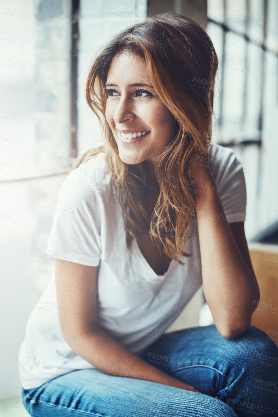 Buy stock photo Shot of an attractive and thoughtful young woman relaxing at home