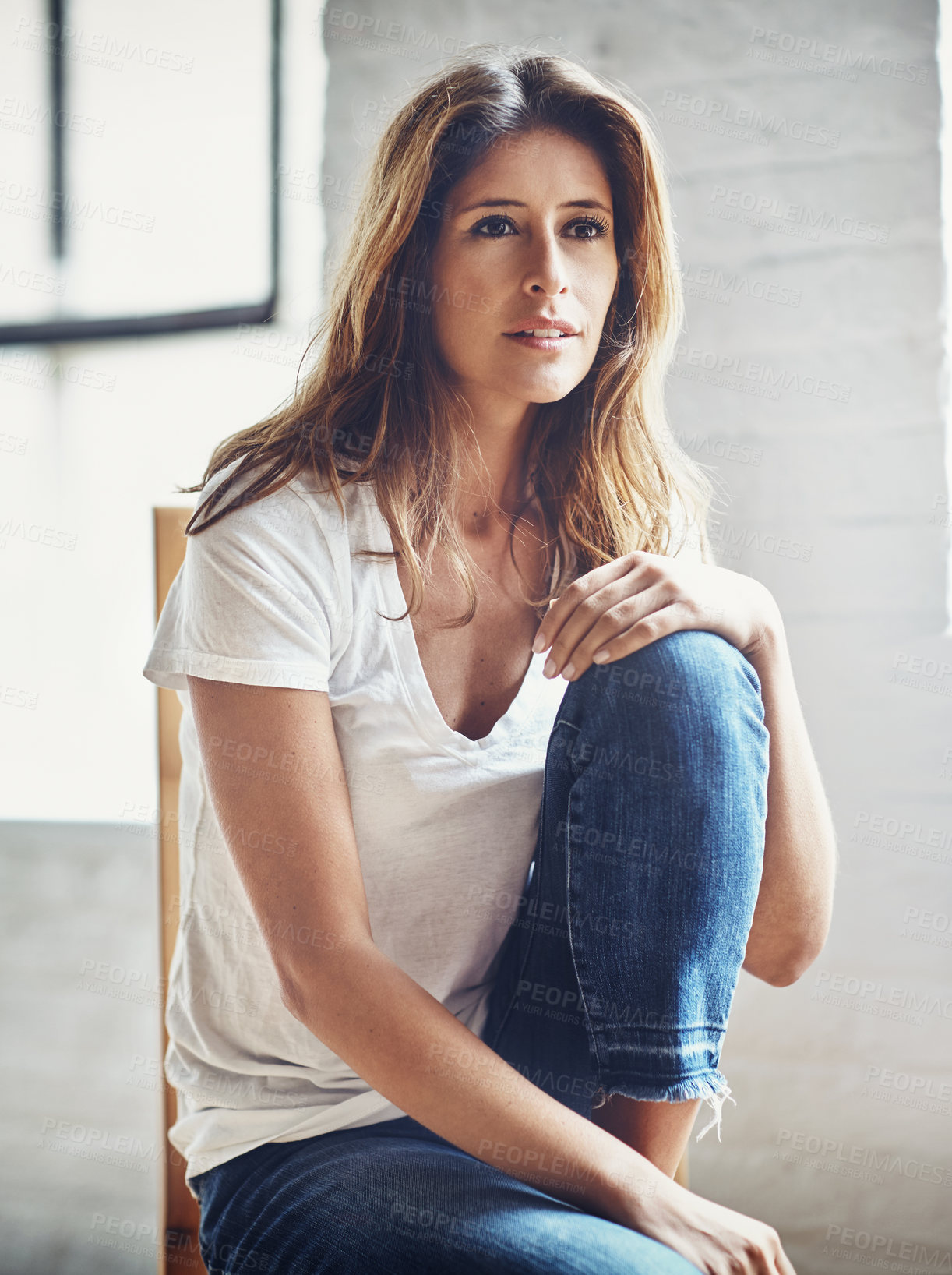 Buy stock photo Shot of an attractive and thoughtful young woman relaxing at home