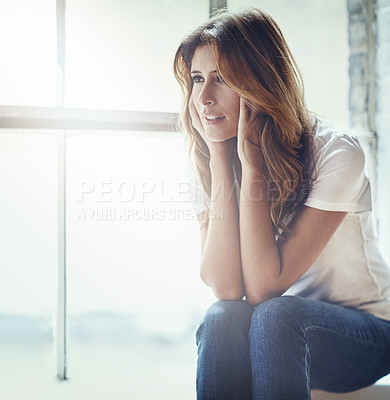 Buy stock photo Shot of an attractive and thoughtful young woman relaxing at home