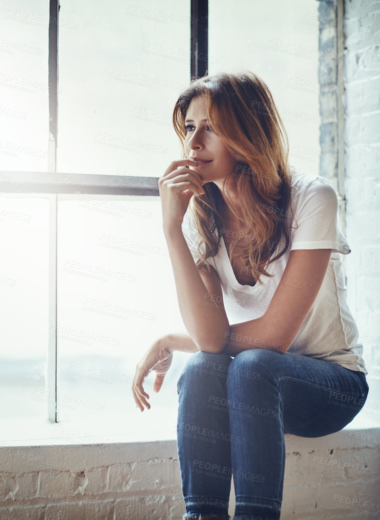 Buy stock photo Shot of an attractive and thoughtful young woman relaxing at home