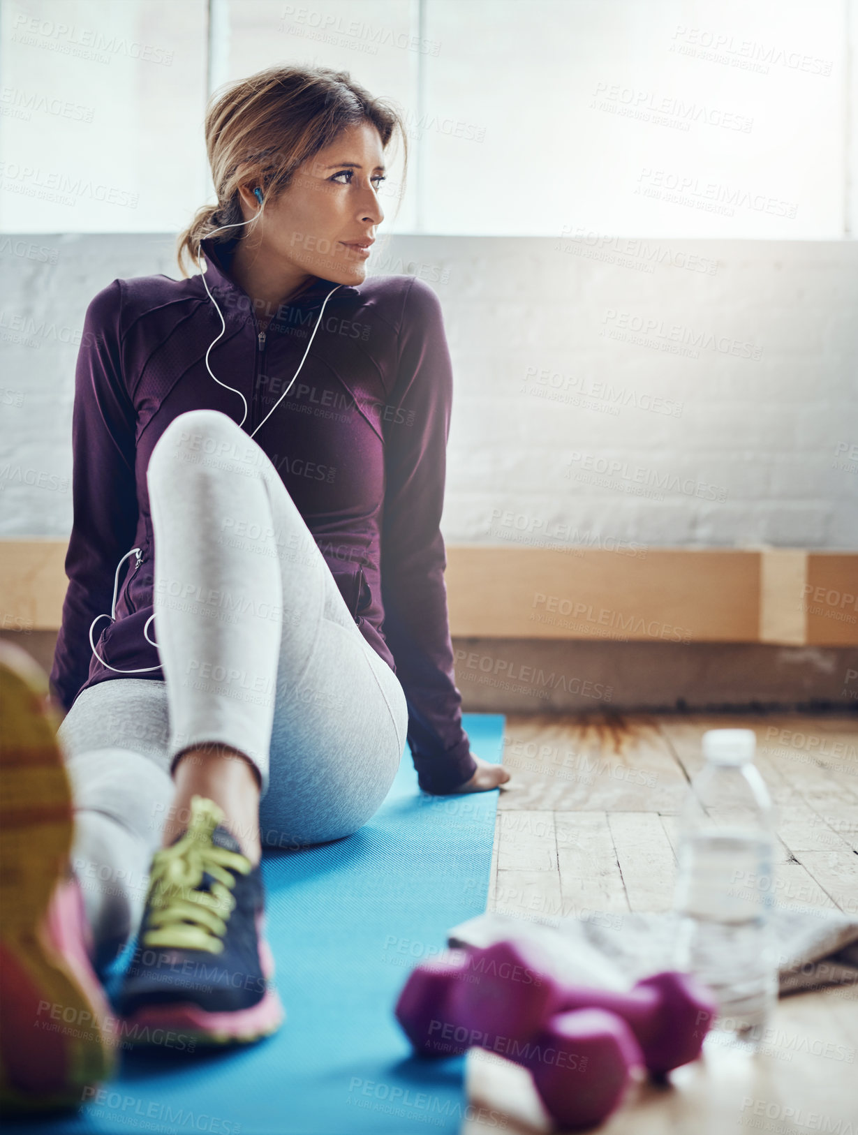 Buy stock photo Shot of an attractive young woman listening to music while working out at home