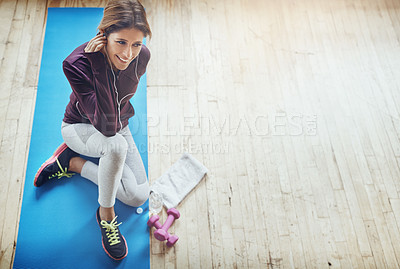 Buy stock photo High angle shot of an attractive young woman listening to music while working out at home