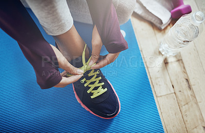 Buy stock photo High angle shot of an unidentifiable woman tying her shoelaces before a workout
