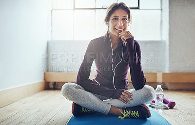 Buy stock photo Portrait of an attractive young woman listening to music while working out at home