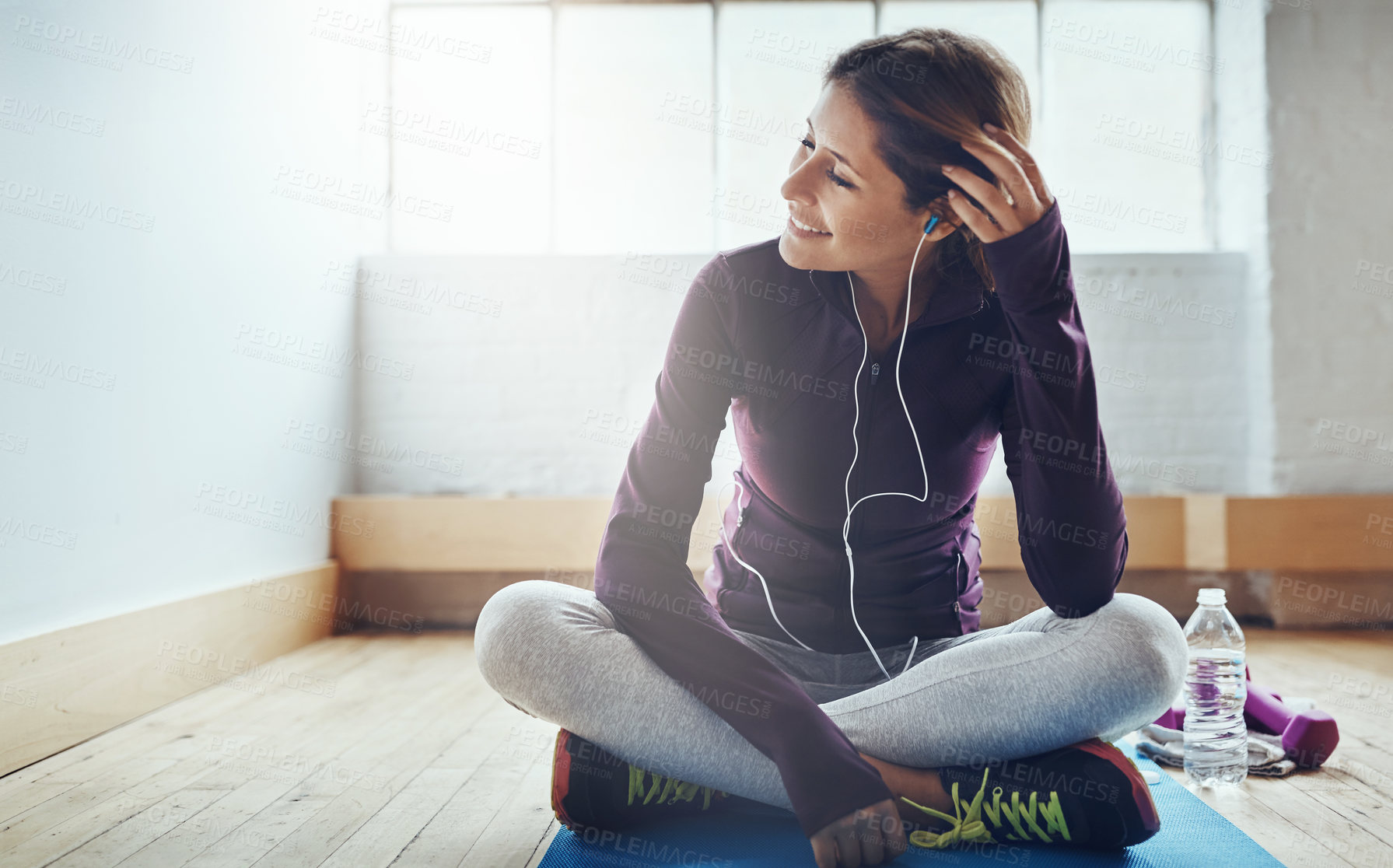 Buy stock photo Shot of an attractive young woman listening to music while working out at home