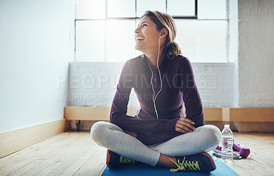 Buy stock photo Shot of an attractive young woman listening to music while working out at home