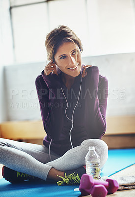 Buy stock photo Shot of an attractive young woman listening to music while working out at home