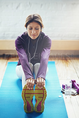 Buy stock photo Shot of an attractive young woman listening to music while working out at home