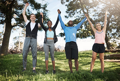 Buy stock photo Shot of a group of people raising their hands in victory while out exercising