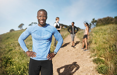 Buy stock photo Portrait of a young man exercising outside with people in the background