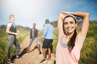 Buy stock photo Portrait of a young woman exercising outside with people in the background
