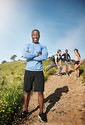 Buy stock photo Portrait of a young man exercising outside with people in the background