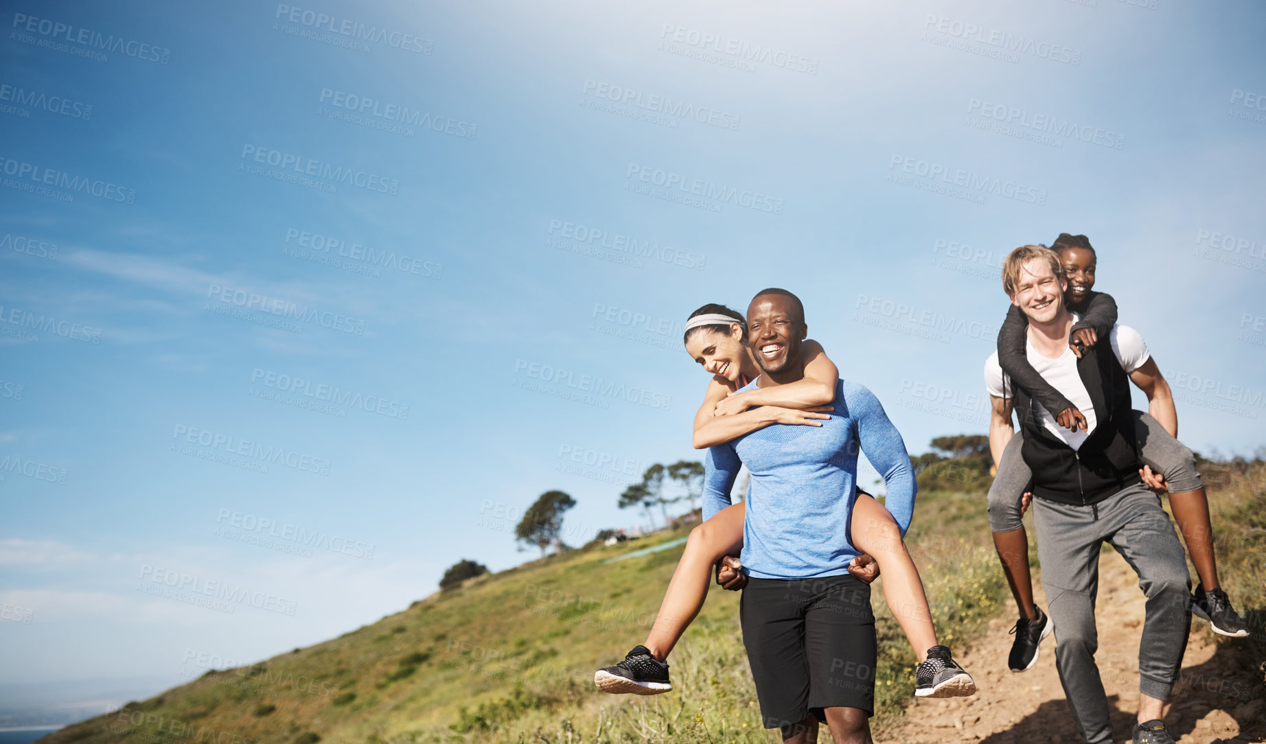 Buy stock photo Happy, couple and piggyback for hiking outdoor with fitness challenge, mountain travel and trekking journey. Smile, diversity and people walking for exercise, blue sky and bonding adventure of health