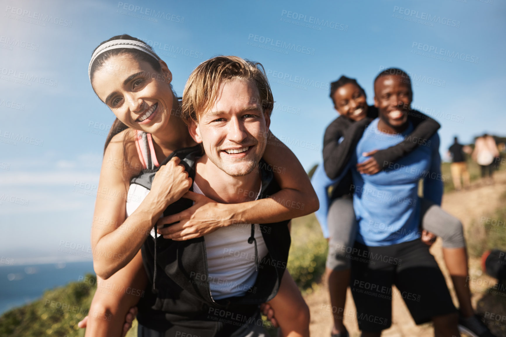 Buy stock photo Shot of two men challenging each other by carrying their girlfriends downhill