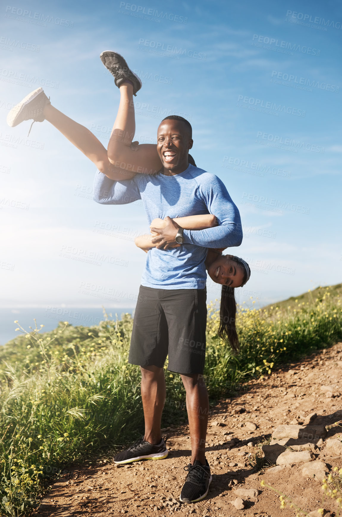 Buy stock photo Shot of a muscular man carrying his girlfriend over his shoulders