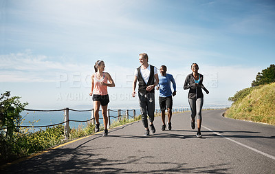 Buy stock photo Shot of a group of people out running together