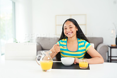 Buy stock photo Portrait of a happy young girl enjoying a healthy breakfast at home