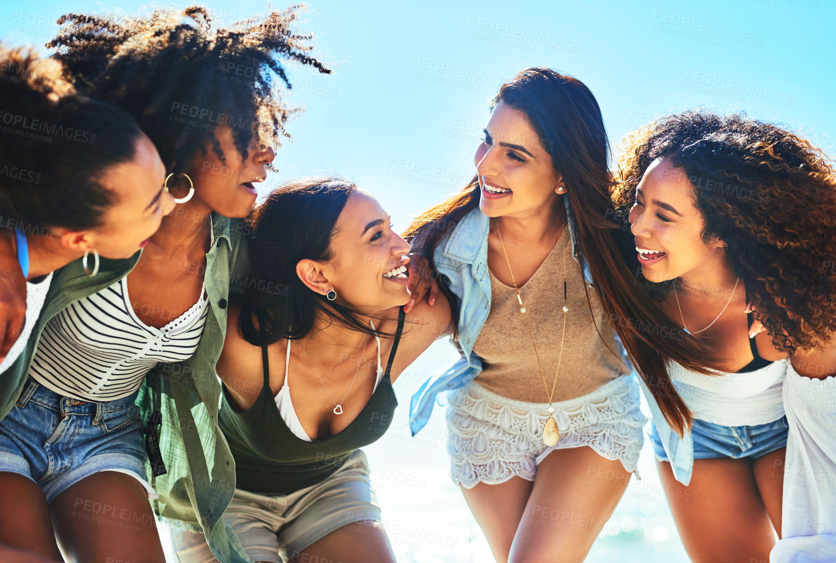 Buy stock photo Shot of a group of girlfriends spending the day at the beach