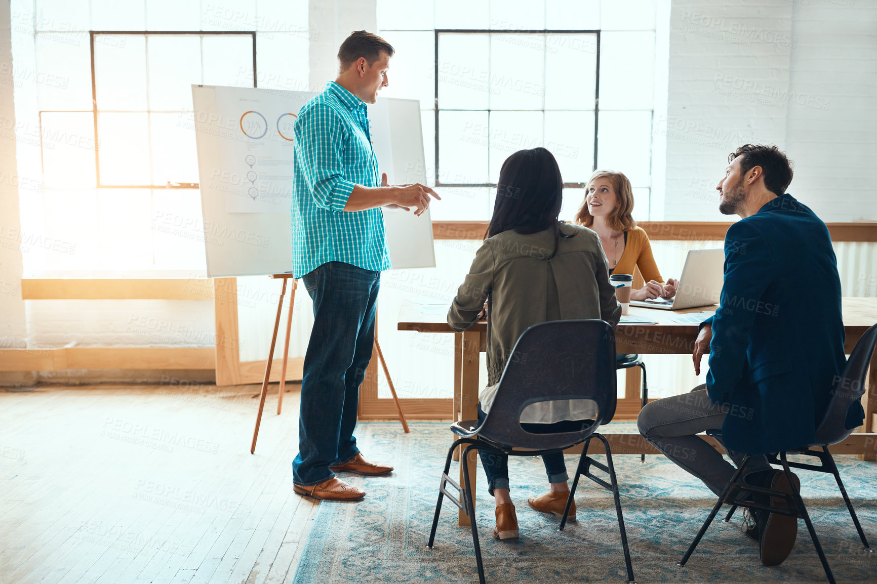 Buy stock photo Shot of a group of young businesspeople having a meeting in a modern office