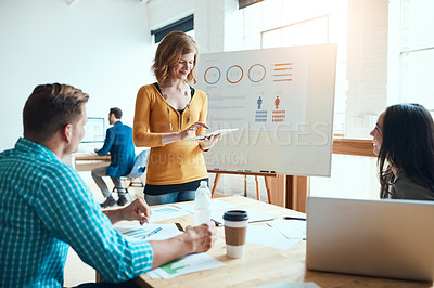 Buy stock photo Shot of a young businesswoman using a digital during a meeting with her colleagues in a modern office