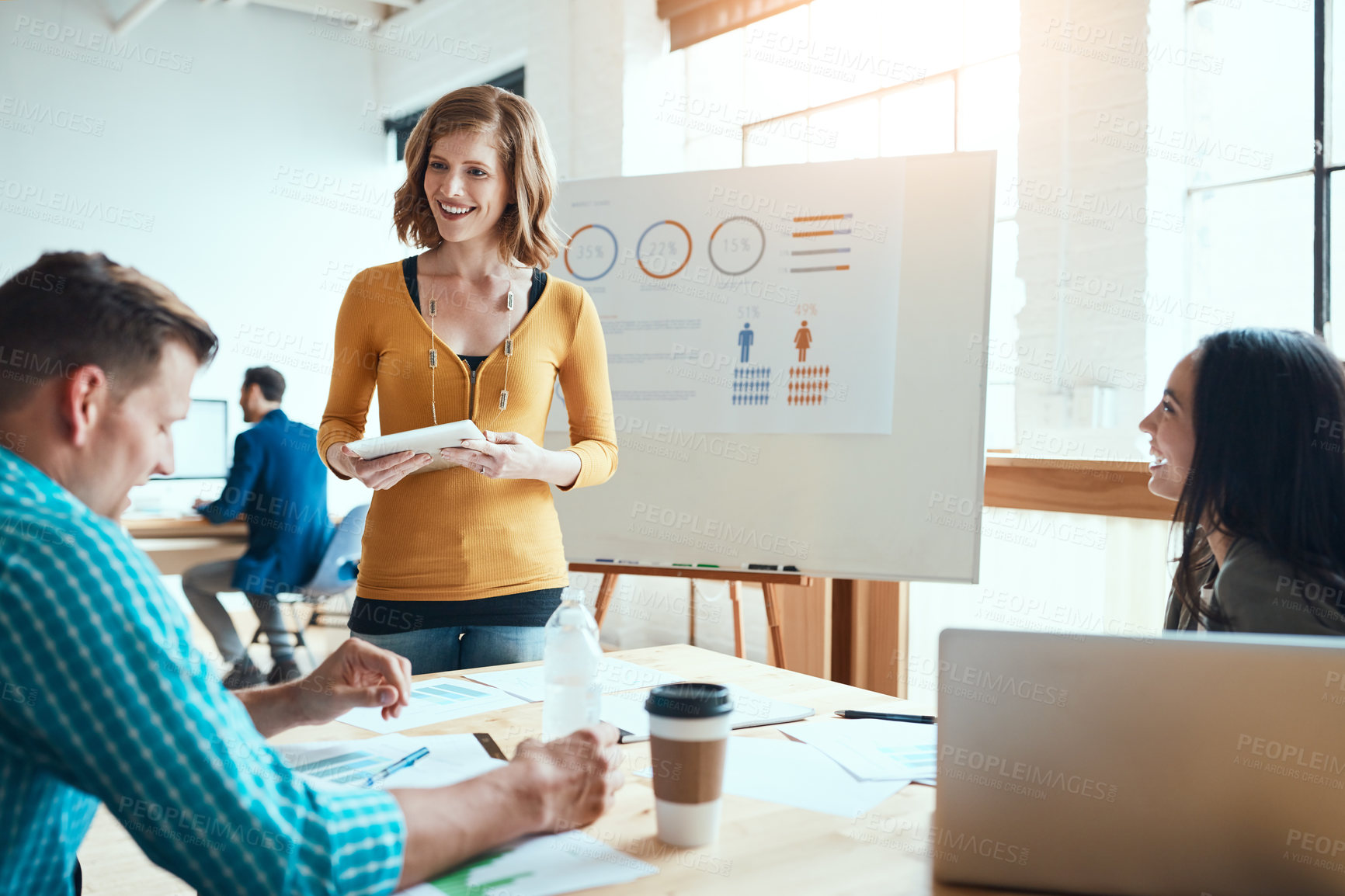 Buy stock photo Shot of a young businesswoman using a digital during a meeting with her colleagues in a modern office