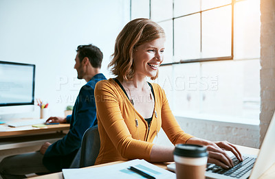 Buy stock photo Cropped shot of an attractive young businesswoman working on her laptop in a modern office