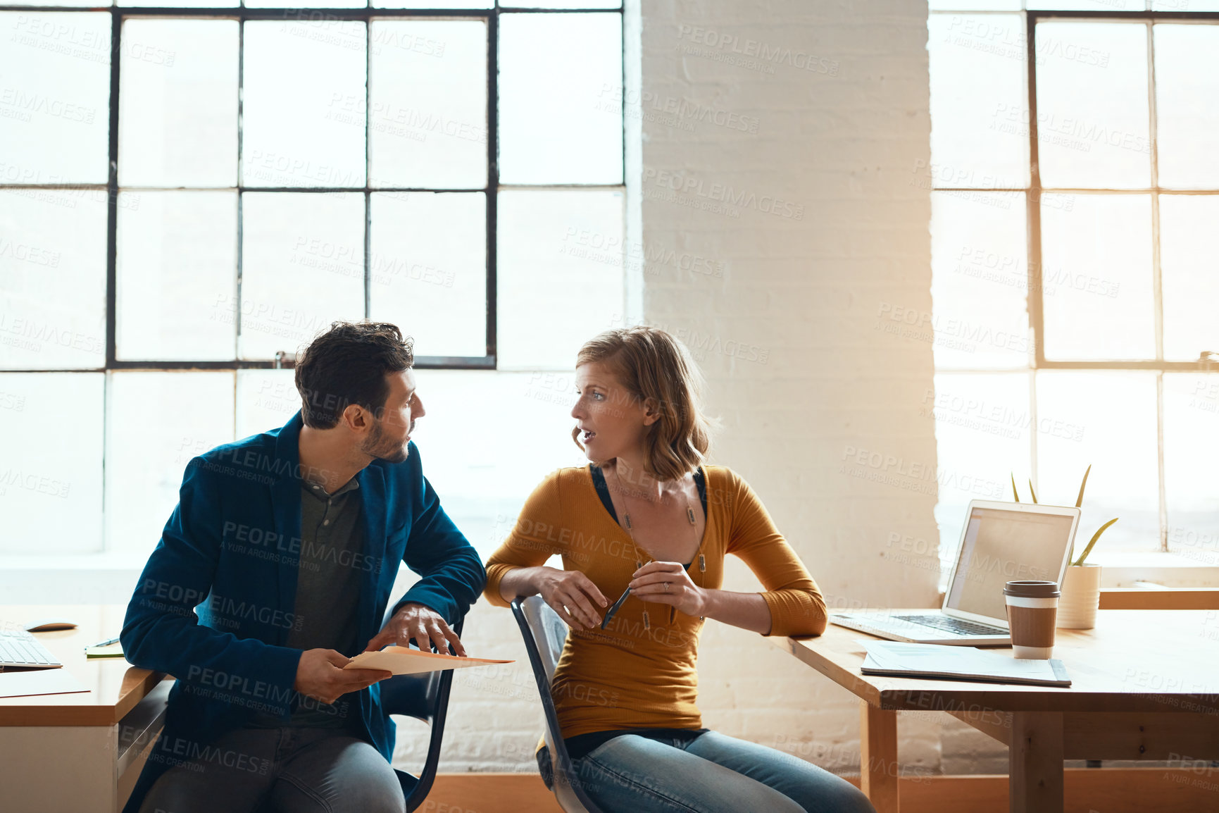 Buy stock photo Cropped shot of two young businesspeople working together in a modern office